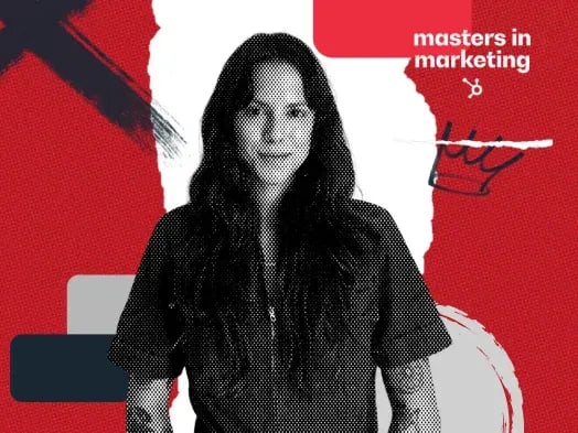 A woman with long dark hair, a short-sleeved shirt, and arm tattoos.